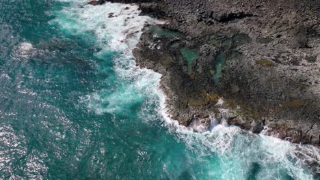 Hawaii's-coastal-allure-is-marked-by-perilous-beauty,-featuring-towering-white-waves-and-volcanic-rock
