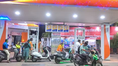 Cinematic-shot,-people-are-filling-petrol-in-tovilles-at-night-due-to-rising-fuel-prices