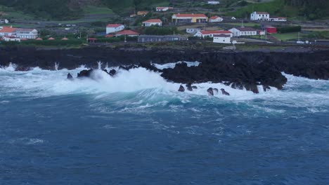 Rough-sea-at-Fajã-Grande-town-at-Flores-island-during-cloudy-day,-aerial