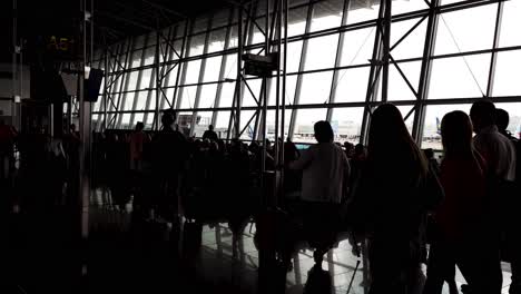 Cinematic-travel-shot-of-people-silhouettes-walking-in-the-terminal-hall-at-the-airport---Brussels,-Belgium