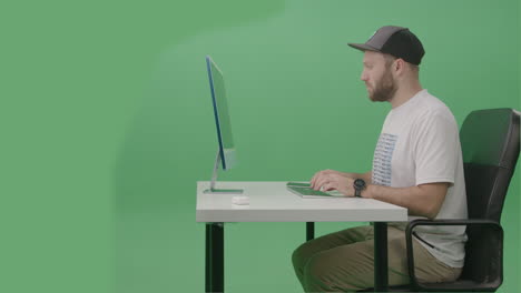 Young-Man-Developer-Using-Computer-To-Write-Code-on-his-desktop-computer-In-Green-Screen-Studio