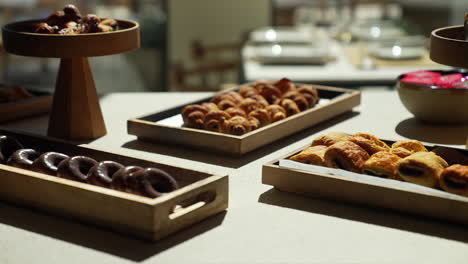 Pastry-table-at-a-hotel-brunch-with-glamorous-cakes-and-croissants-beautifully-lit-by-sun