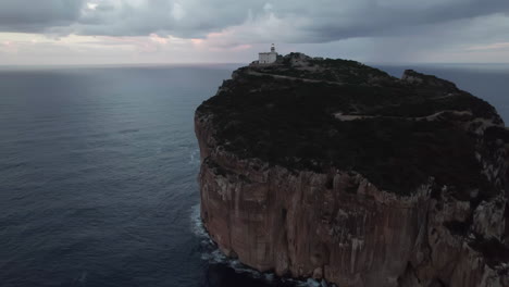 Kap-Caccia,-Sardinien:-Luftaufnahme-Im-Orbit-Des-Beleuchteten-Leuchtturms-Dieses-Berühmten-Kaps-Und-Bei-Sonnenuntergang