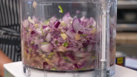 Chopping-and-mixing-red-onion,-pepper,-cilantro,-garlic-and-other-ingredients-in-a-food-processor---Chana-Masala-series