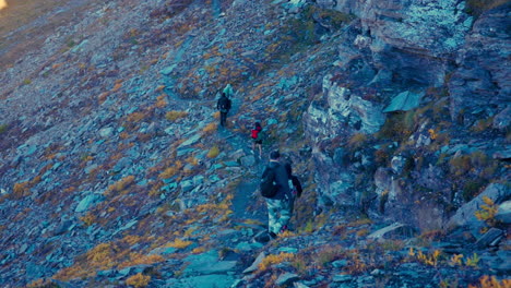 Group-of-Young-Tourists-Hiking-Along-Rocky-Mountainous-Pathway-in-Courmayeur-Region-in-Italian-Alps-in-Autumn-Season