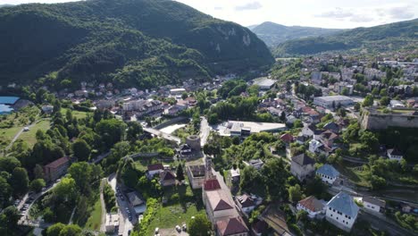 Aerial-pullback-over-the-Picturesque-city-of-Jajce-surrounded-by-forested-mountains,-Bosnia-and-Herzegovina