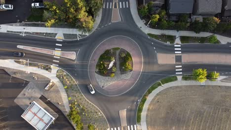 Rising-and-rotating-shot-of-roundabout-in-Bend,-Oregon-with-cars-circling