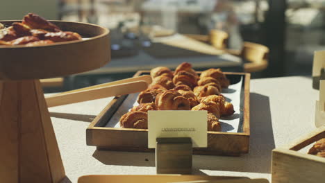 Frisch-Gebackene-Croissants,-Präsentiert-Auf-Einem-Holzteller-Bei-Einem-Herrlichen-Und-Sonnigen-Morgenbrunch,-Sorgen-Für-Ein-Köstliches-Und-Optisch-Ansprechendes-Frühstückserlebnis