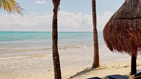 Schwenk-Nach-Links:-Aufnahme-Des-Trs-Beach-Resort-In-Tulum,-Cancun,-Mexiko,-Mit-Blick-Auf-Den-Strand-Und-Das-Karibische-Meer-Mit-Palmen-Und-Cabanas-Im-Vordergrund