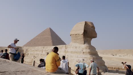 Tourists-watching-the-famous-sphinx-and-pyramids-of-Giza,-statues-resembling-lion-and-human-silhouettes,-Egypt,-Cairo