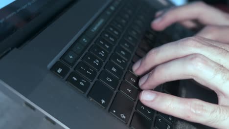Close-up-of-man's-hands-swiftly-typing-on-laptop-keyboard