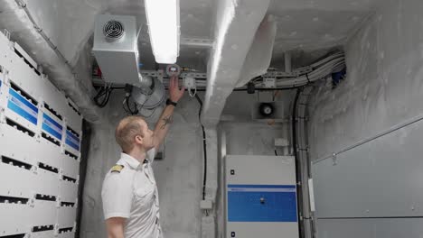 Kapitän-Zeigt-Auf-Gasdetektor-Im-Dach-Des-Schiffsbatterieraums