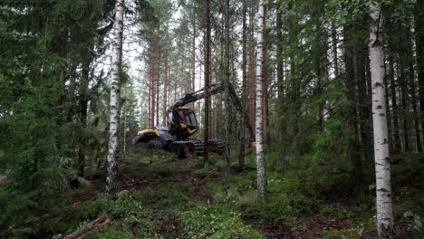 Aerial-sideways-shot-of-Scandinavian-finnish-forest-and-forestry-machine-Ponsse-Scorpion-harvester-filmed-with-DJI-Air-2s