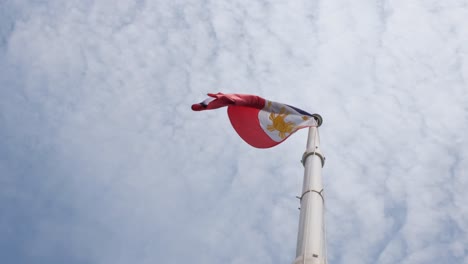Volada-Hacia-La-Izquierda-Por-Algo-De-Viento-Durante-Un-Día-Nublado,-Bandera-Nacional-Filipina