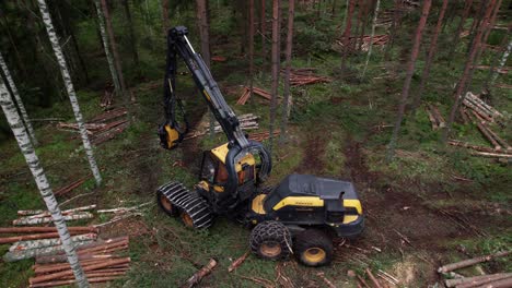 Aerial-following-shot-of-Scandinavian-finnish-forest-and-forestry-machine-Ponsse-Scorpion-harvester-passing-by,-shot-with-DJI-Air-2s