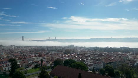 Bird's-eye-view-of-Lisbon-with-the-25-de-Abril-bridge-emerging-from-a-misty-river