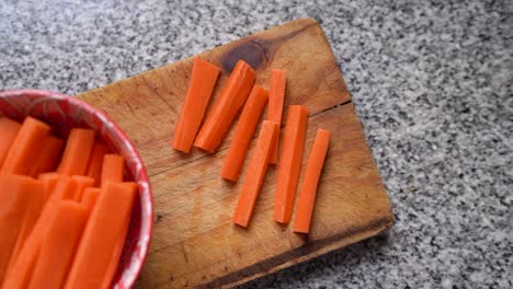 Zanahorias-Cortadas-En-Palitos-Sobre-Tabla-De-Madera