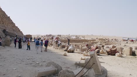 Turistas-Caminando-Alrededor-Y-Desde-La-Sombra-De-Las-Pirámides-Egipcias,-Pirámides-De-La-Unesco-El-Cairo-Egipto