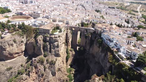 Aerial-view-captures-Ronda's-iconic-bridge-in-Spain,-gracefully-connecting-the-charming-village-with-architectural-splendor