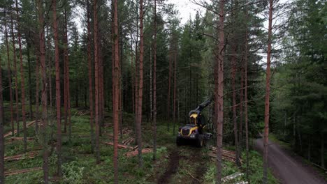 Aerial-following-shot-of-Scandinavian-finnish-forest-and-forestry-machine-Ponsse-Scorpion-harvester,-shot-with-DJI-Air-2s