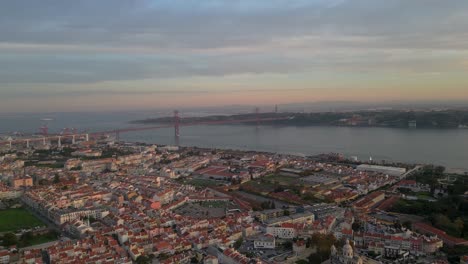 Luftaufnahme-Von-Lissabon-Mit-Schwerpunkt-Auf-Der-Brücke-25-De-April-Kurz-Vor-Sonnenuntergang