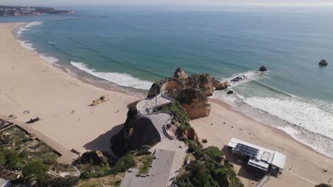 Orbiting-shot-over-Três-Castelos-viewpoint-in-Rocha-Beach-on-sunny-day,-Portimão