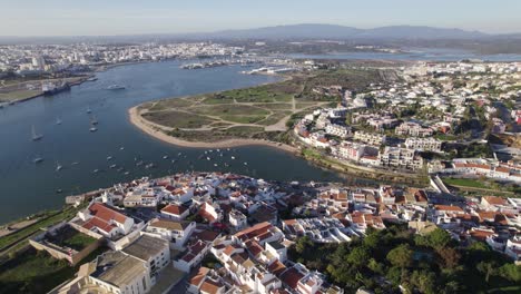 Aerial-establishing-shot-of-Ferragudo-village-by-Arade-River-next-to-Portimão,-Algarve