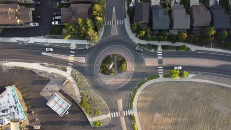 Descending-shot-of-Roundabout-in-Bend,-Oregon-with-cars-driving-around-it