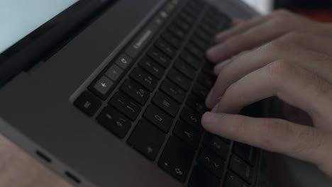 Slow-motion-close-up-of-male-fingers-typing-on-grey-laptop