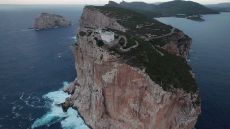 Cape-Caccia,-Sardinia:-wonderful-aerial-view-in-orbit-of-the-lighthouse-of-this-famous-cape-on-the-island-of-Sardinia-and-during-sunset