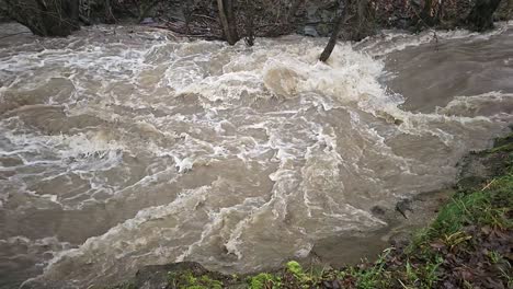 Agua-Sucia-De-Inundación-Que-Fluye-Rápidamente-En-El-Río,-Primer-Plano-Abstracto,-Vídeo-En-Cámara-Súper-Lenta