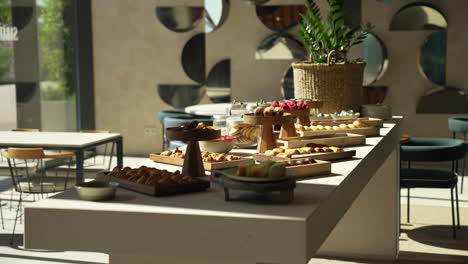 Pastry-table-at-a-hotel-brunch-with-glamorous-cakes-and-croissants-beautifully-lit-by-sun