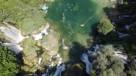 Topdown-view-of-mesmerizing-Kravica-Waterfall-with-emerald-colored-water,-Tilt-up-Shot
