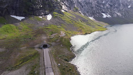 Vista-Aérea-Del-Túnel-De-Carretera-Junto-Al-Lago-A-Través-De-La-Montaña-Hasta-El-Fiordo-De-Geiranger-En-La-Región-De-Geiranger-En-Noruega