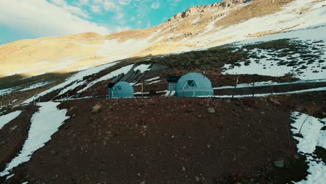 Two-luxurious-glamping-domes,-nestled-harmoniously-amid-the-majestic-peaks-of-the-Argentinean-Andes