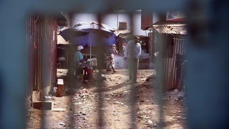 Vista-De-La-Gente-En-La-Calle-En-Kibera-A-Través-De-Una-Puerta.
