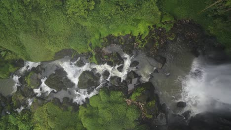 Aerial-top-down-drone-descending-vertically-into-the-Waterfall-and-river-stream-of-Penatapan-Forest-at-Berastagi,-North-Sumatera,-Indonesia