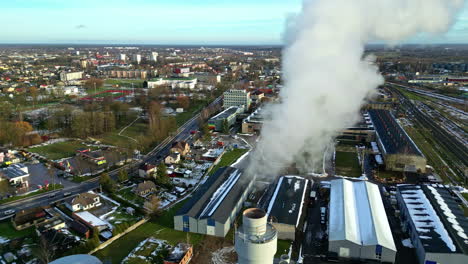 Industrial-Power-Plant-with-Steam-Billowing-Out-of-Chimney-Over-a-City-in-Europe