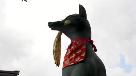 Statue-Eines-Inari-Fuchses,-Der-Bei-Fushimi-Inari-Taisha-Die-Goldene-Reisernte-Im-Mund-Hält