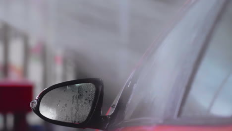 Autowäsche:-Wasserstrahl-Auf-Rotes-Seitenfenster-Des-Autos-Sprühen