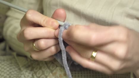 Close-up-of-human-hands-crocheting-with-needles-and-wool-knitting-a-small-warm-garment-for-the-winter