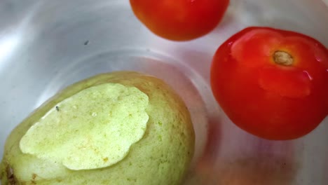 close-up-of-tomatoes-and-guava-on-water