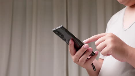 Junger-Mann-Schreibt-SMS-Auf-Smartphone-Vor-Grauem-Hintergrund