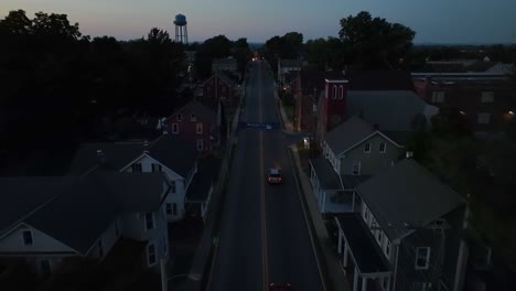 Dusk-settles-over-a-quiet,-lamp-lit-street-in-a-small-town