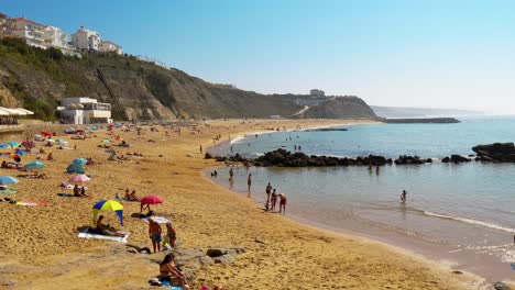 Portugal,-Ericeira,-Praia-da-Baleia-sandy-beach-with-people-during-autumn