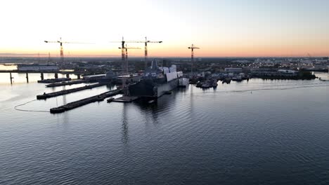 Large-military-ship-building-dry-dock-on-Elizabeth-River-in-Norfolk,-Virginia-at-sunrise