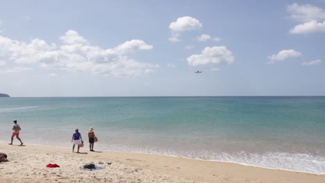 Tourists-watching-an-airplane-flying-very-close-overhead-while-landing-at-Phuket-International-Airport-on-Mai-Khao-beach