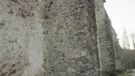 A-close-up-view-of-the-ancient-stone-wall-of-the-14th-century-Gothic-church-in-Velhartice-with-its-rough-and-weathered-structure