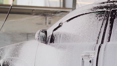 Slow-Motion-Car-Wash-with-Spray-Foam-Soap-on-a-Sleek-Black-Beauty