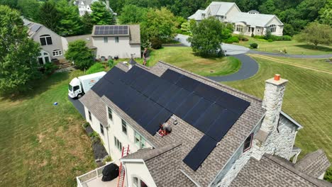 Male-workers-installing-solar-panels-on-residential-shingle-roof-of-house-in-USA